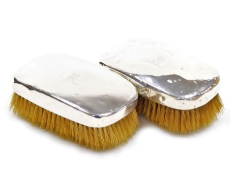A pair of George V silver mounted clothes brushes, each with engine turned decoration and engraved monogram for AO, Birmingha
