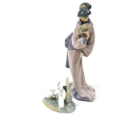 A Nao porcelain figure of a Japanese geisha girl, holding a fan, 32.5cm high, and a Nao figure of three ducks. (2)