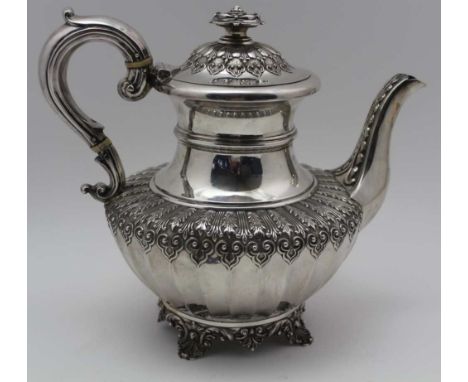 J. WRANGHAM & WILLIAM MOULSON, A SILVER TEAPOT, hinged cover with floral knop, leaf and scroll repousse shoulders, on scallop