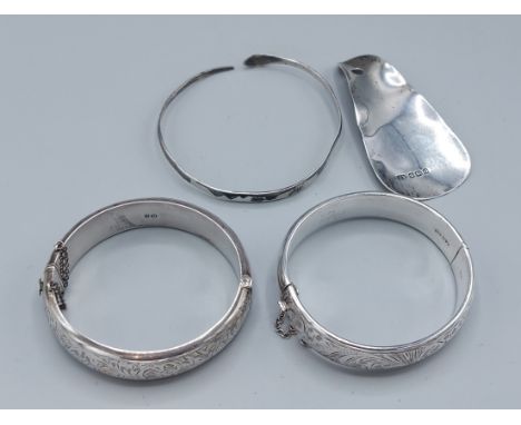A Chester silver bangle together with another Chester silver bangle, an Eastern bangle and a Sheffield silver shoehorn 