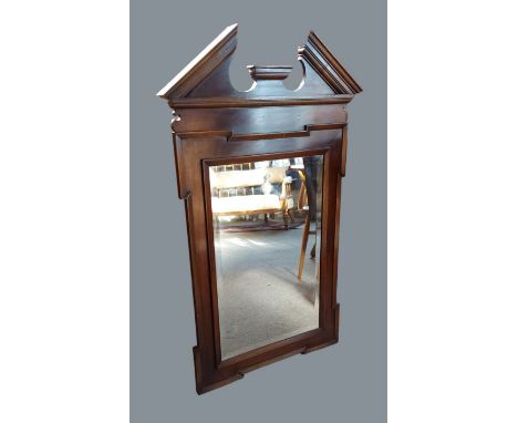 A rectangular Chippendale style wall mirror, the architectural pdiment above a rectangular plate mirror, 104cms x 64cms 