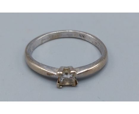 An 18ct white gold ring set with a single square cut diamond, ring size M, 2.7gms 