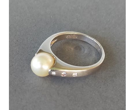 An 18ct white gold ring set with a central pearl flanked by diamond shoulders, 6.5gms 