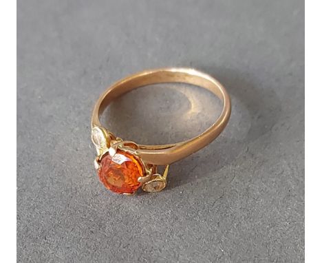 A 9ct gold ring set with a central orange stone flanked by clear stones, 3.1gms 