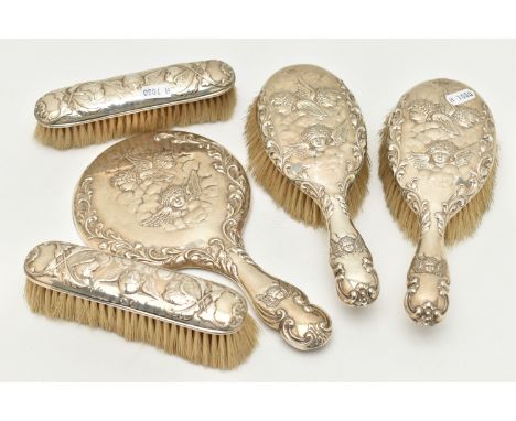 FIVE SILVER VANITY ITEMS, to include a hand held mirror and two hair brushes, embossed cherubs and foliate pattern, each piec