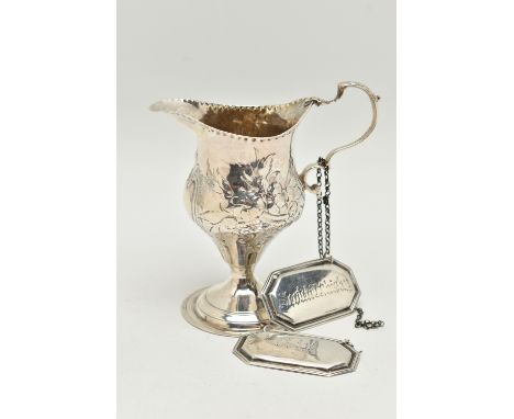 A GEORGE III SILVER BALUSTER CREAM JUG AND A PAIR OF EDWARDIAN SILVER DECANTER LABELS, the cream jug with later foliate repou