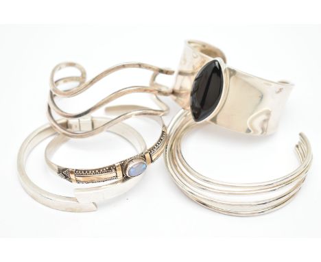 FIVE WHITE METAL BANGLES, the first a wide white metal cuff bangle, set with a navette cabochon onyx, stamped Mexico 925, a w