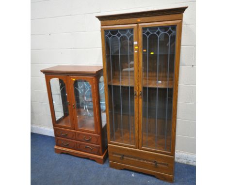 AN OAK EFFECT DOUBLE DOOR DISPLAY CABINET, with two glass shelves and a single wooden shelf, width 87cm x depth 40cm x height
