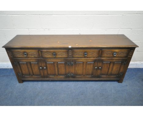 AN EARLY 20TH CENTURY OAK SIDEBOARD, fitted with four drawers, above four cupboard doors, length 191cm x depth 46cm x height 