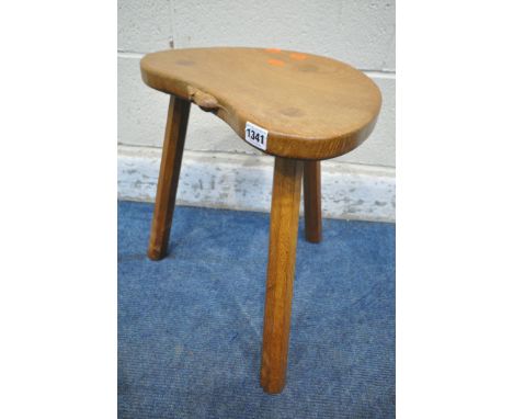 ROBERT 'MOUSEMAN' THOMPSON, KILBURN, AN OAK KIDNEY SHAPED CALF STOOL, raised on three octagonal legs, the signature mouse tra
