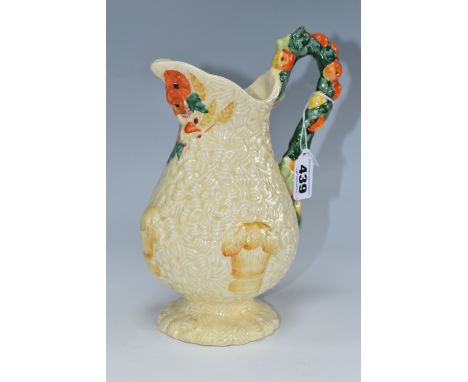 A CLARICE CLIFF 'CELTIC HARVEST' JUG, moulded and painted with fruit and wheatsheaves on a textured ground, green printed bac