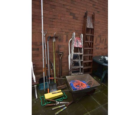 A SELECTION OF GARDEN HAND TOOLS, etc, to include spades, forks, shovels, etc, along with a wheelbarrow, two wooden ladders a