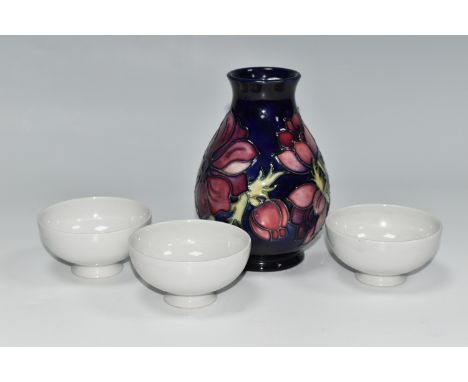 A MOORCROFT POTTERY 'ANEMONE' VASE AND THREE BLANK MOORCROFT BOWLS, the baluster vase tube lined with purple anemone flowers 