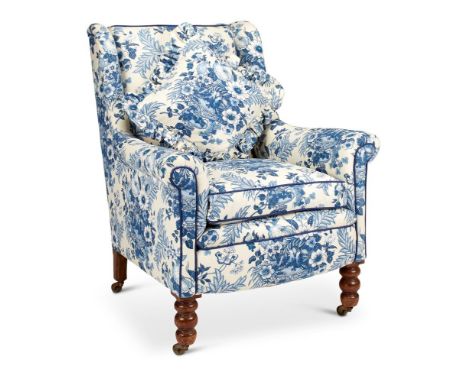 A LATE VICTORIAN MAHOGANY AND UPHOLSTERED WING ARMCHAIRCovered in blue chintz, possibly by Colefax and Fowler, on bobbin turn