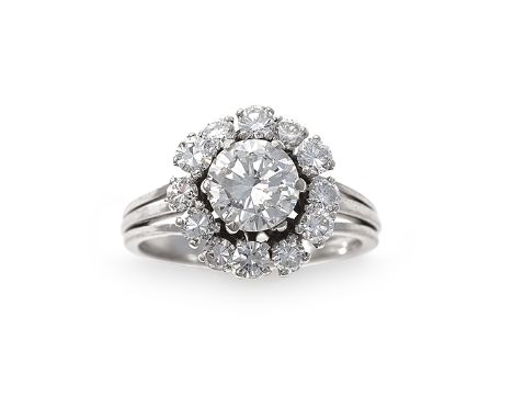 A diamond ring, composed of a round brilliant-cut diamond within a six-claw setting to a surround of round brilliant-cut diam