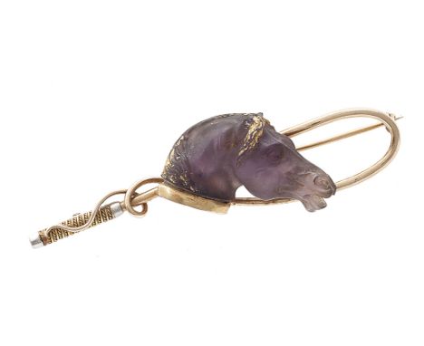 An early 20th century equestrian brooch, composed of a carved amethyst head of a horse to a 14 carat gold riding whip, length