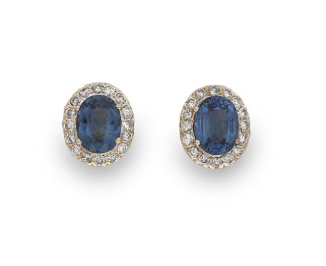 A pair of diamond and sapphire earrings, each earring composed of an oval mixed-cut sapphire to a surround of round brilliant