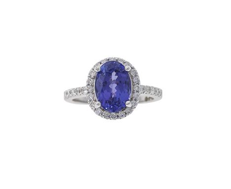 A diamond and tanzanite ring, composed of an oval mixed-cut tanzanite to a surround of round brilliant-cut diamonds and an 18