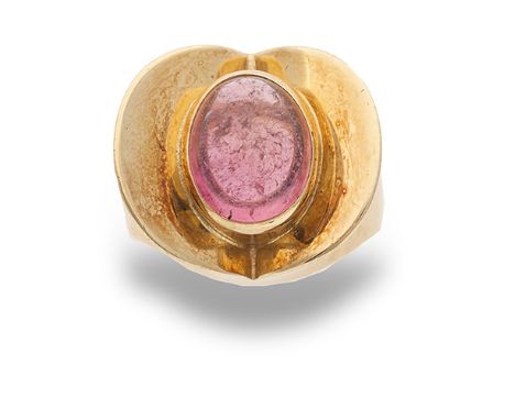 A tourmaline and 18 carat gold ring by Rudolf Heltzel, the pink cabochon-cut tourmaline raised in a collet setting between a 