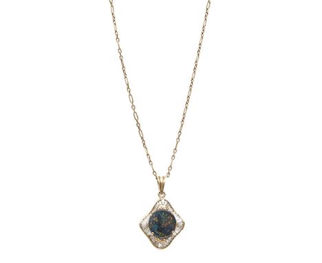 A diamond and black opal pendant, composed of an oval cabochon black opal to a scrolled graduated baguette-cut diamond surrou