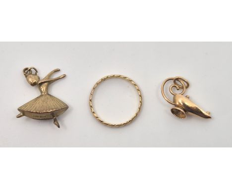 A 14ct. gold band, size UK L (1.0g), together with 9ct. gold ballerina charm (1.1g), and unmarked yellow metal magic lamp cha