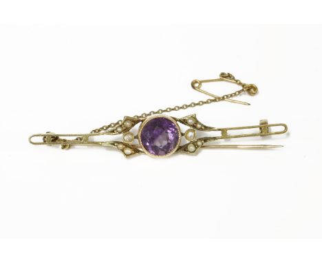 An Edwardian gold single stone round cut amethyst bar brooch, flanked with seed pearls4.37g