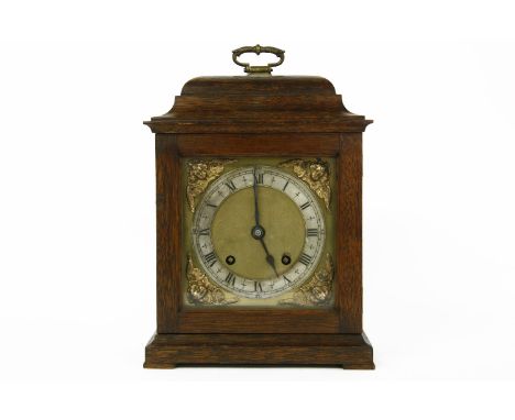 An early 20th oak cased table clock, striking on a gong