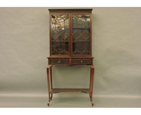 An early 20th century Chippendale revival mahogany display cabinet,  with a pair of astragal glazed doors above two frieze dr