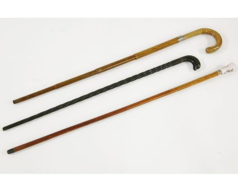 Three walking sticks, the first as a concealed umbrella, with telescopic wooden tube shaft, the second with a painted porcela