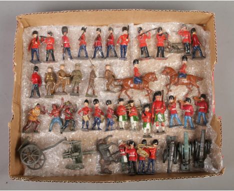 A tray of vintage painted lead military figures, including cannons, soldiers on horseback and musicians.  