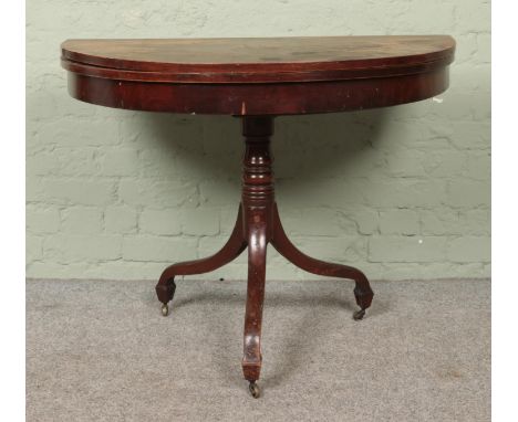 A mahogany fold over card table of demi-lune form on turned pedestal base.Hx73cmWx99cmDx50cm  