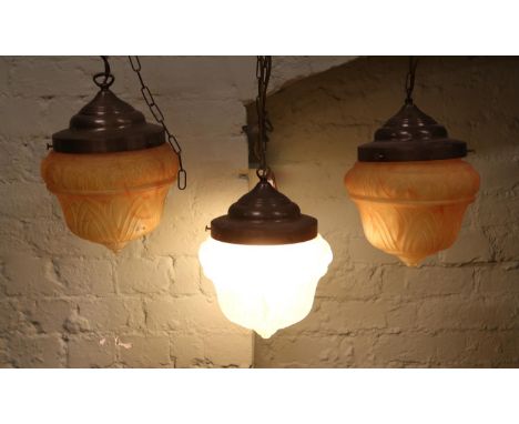 Three Art Deco hanging light fittings, with flamed amber coloured shades. One with power cable.  
