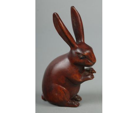 A hand carved hardwood netsuke of a rabbit, signed to base.  
