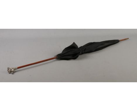 A vintage parasol featuring white metal handled formed as a young maiden.  