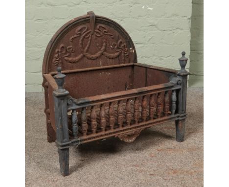 A nineteenth century cast iron and brass fire grate, with arched top and swag and bow decoration.  