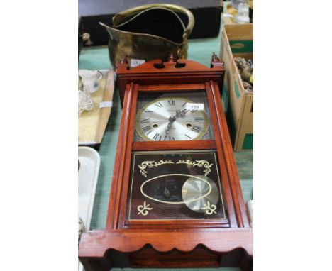 A modern wall clock plus a brass coal helmet