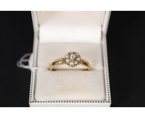 A 22ct gold ring with seed pearl and diamond cluster, the band has ornate rope decoration, size Y