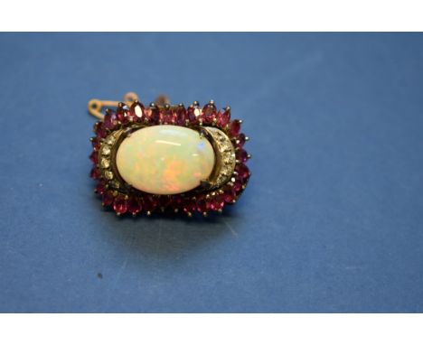 A cabochon opal pendant brooch, having five diamonds set either side and surrounded by oval rubies. Condition Report: Appears