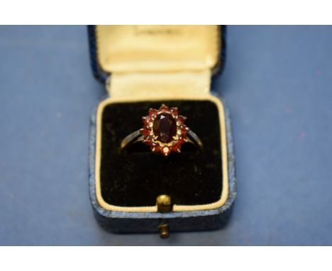 A Victorian garnet hinged bangle; together with a silver garnet ring; and three other items of costume jewellery in a cross s