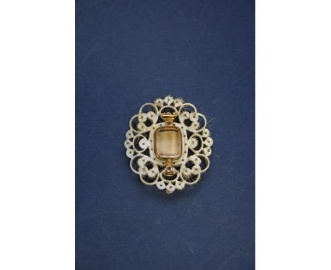A mother of pearl and seed pearl mourning brooch containing a portrait miniature of a Georgian gentleman, having compartment 