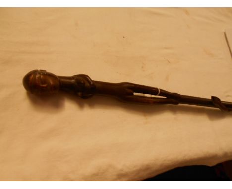 A carved African walking stick depicting naked female and climbing serpent