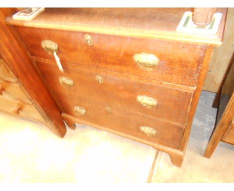 A Georgian oak chest of three graduated drawers, each having brass conch shell drop handles, escutcheon's and raised on brack