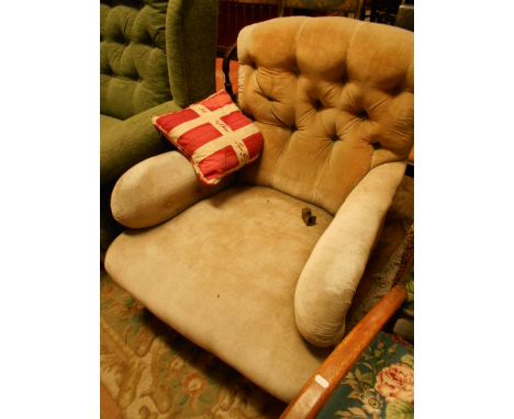 A Victorian button-back armchair having scrolled arms in need of restoration