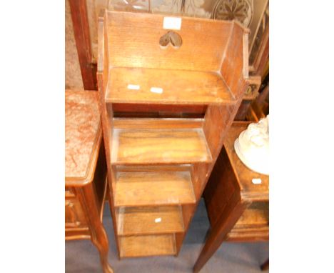 A Libertys style narrow oak arts and crafts five shelf bookcase with carved floral rosettes to sides, 113 cm high x 30 cm wid