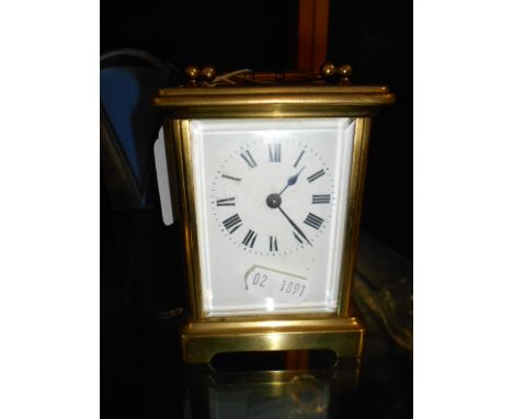 A mid 20th C French brass carriage clock with enamel dial and Roman numeral and bevelled glass viewing panels 