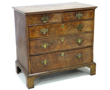 An early 18th century walnut veneered and crossbanded chest of two short over three long graduating drawers, with later brass
