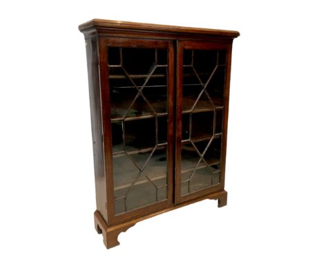 An early 20th century mahogany bookcase, with four adjustable shelves enclosed by two glazed doors, raised upon bracket feet,