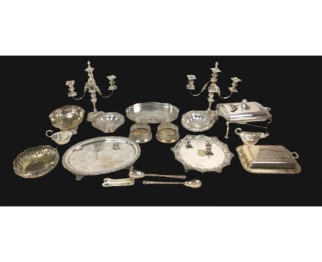 A collection of silver plated wares, including a pair of candelabra, a lidded serving dish on stand, two wine bottle coasters