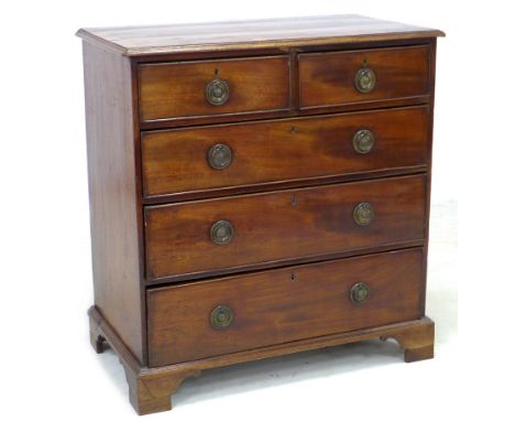 A George III mahogany chest of two sort over three long drawers, cock beading and brass ring handles, raised on bracket feet,