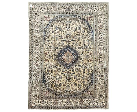 Persian Nain ivory ground carpet, central indigo medallion, the busy floral field decorated with scrolling vines and flower h
